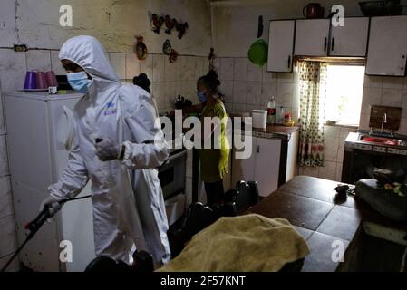 Sucre, Venezuela. März 2021, 24th. Ein Angestellter des Bürgermeisters von Sucre sprüht eine Lösung aus Hypochlorit und Wasser, um die Ausbreitung von Covid-19 in einem Haus im Sektor Cuatricentenario des beliebten Viertels Petare zu verhindern. Kredit: Jesus Vargas/dpa/Alamy Live Nachrichten Stockfoto