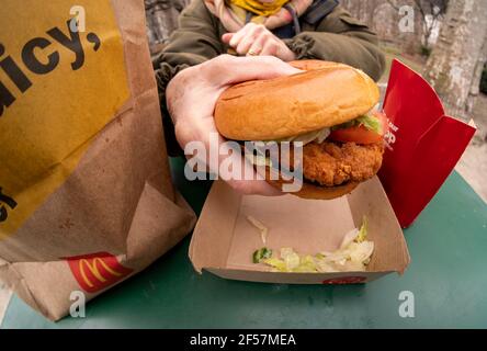 Ein Diner bereitet das Mittagessen auf einem McDonald's Crispy Chicken Sandwich Deluxe zu, während er am Mittwoch, 17. März 2021, im Freien in New York zu Abend gegessen hat. In 2019 Popeye debütierte seine Huhn-Sandwich zu großem Erfolg führt fast jede Fast-Food-Kette zu einem knusprigen Huhn Menüelement zu generieren. McDonald's ist endlich als 800-Pfund-Gorilla eingestiegen und hat bereits zu einem Fußverkehr in seinen Restaurants geführt. (© Richard B. Levine) Stockfoto