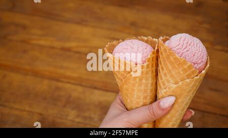 Nahaufnahme der Frau Hand hält zwei Himbeer-Eis Creme Stockfoto