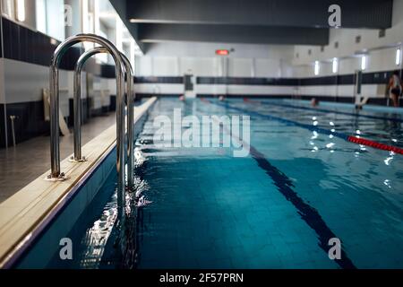 Geländer zum Verlassen des Pools. Kühles und sauberes Wasser im Schwimmbad für Entspannung und Sporttraining Stockfoto