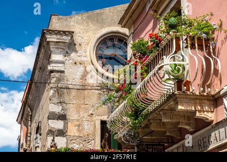 Typisch sizilianischen Balkon von historischen Gebäuden im Stadtzentrum von Taormina, voller Blumen und Dekorationen. Stockfoto