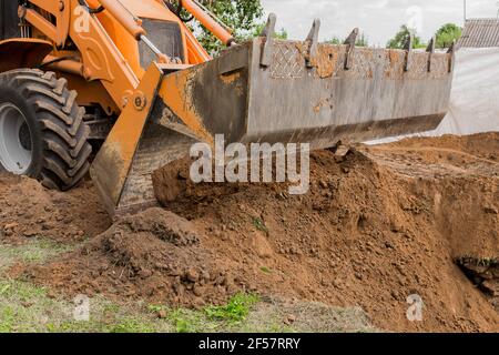 Bagger oder Bulldozer Schaufel flacht den Boden oder Straße in der Industriezone oder Baustelle. Stockfoto