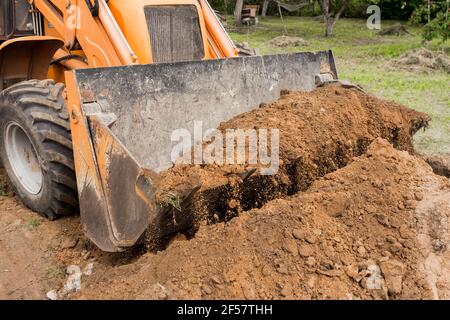 Bagger oder Bulldozer Schaufel flacht den Boden oder Straße in der Industriezone oder Baustelle. Stockfoto