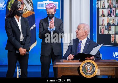 Washington, Usa. März 2021, 24th. US-Präsident Joe Biden, mit Margaret Purce (L), Megan Rapinoe (C) und anderen Mitgliedern der US-Fußballnationalmannschaft WomenÕs, unterzeichnet eine Proklamation während einer Veranstaltung zum Tag der Entlohnung im Staatlichen Speisesaal des Weißen Hauses in Washington, DC, USA, 24. März 2021. Equal Pay Day markiert die zusätzliche Zeit, die es dauert eine durchschnittliche Frau in den Vereinigten Staaten, um den gleichen Lohn zu verdienen, dass ihre männlichen Kollegen im vorherigen Kalenderjahr. Quelle: SIPA USA/Alamy Live News Stockfoto