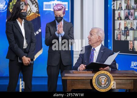 Washington, Usa. März 2021, 24th. US-Präsident Joe Biden, mit Margaret Purce (L), Megan Rapinoe (C) und anderen Mitgliedern der US-Fußball-Frauen-Nationalmannschaft, unterzeichnet eine Proklamation während einer Veranstaltung zum Tag der Entlohnung im Staatlichen Speisesaal des Weißen Hauses in Washington, DC am 24. März 2021. Equal Pay Day markiert die zusätzliche Zeit, die es dauert eine durchschnittliche Frau in den Vereinigten Staaten, um den gleichen Lohn zu verdienen, dass ihre männlichen Kollegen im vorherigen Kalenderjahr. Pool Foto von Shawn Thew Kredit: UPI/Alamy Live Nachrichten Stockfoto