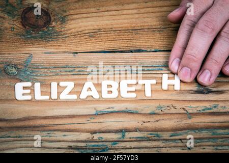 Elizabeth. Name der Frauen und Mädchen. Weiße Buchstaben des Alphabets auf einem hölzernen Hintergrund. Stockfoto