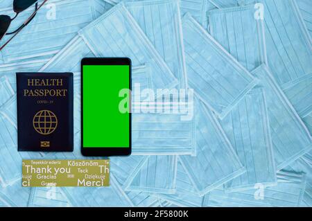 Reisepass und Smartphone mit grünem Bildschirm. Reisekonzept mit Kopierplatz. Health Passport Corona Virus Impfstoff, Chroma Key Mockup Stockfoto