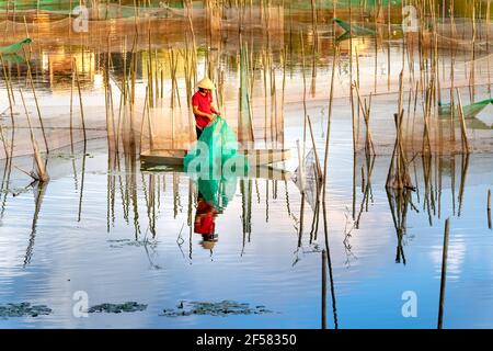 Bao Loc Stadt, Provinz Lam Dong, Vietnam - 12. März 2021: Ein Mann ist die Einrichtung eines Fangnetzes auf einem See in Bao Loc Stadt, Provinz Lam Dong, Vietnam Stockfoto