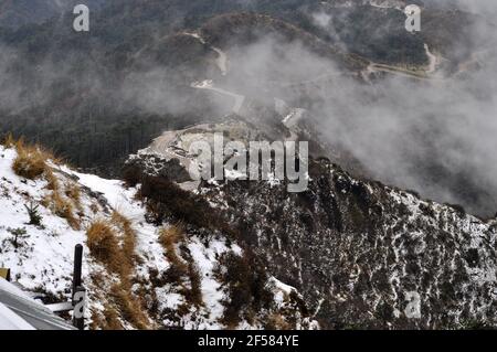 Ariel Blick auf die motorische Straße über die Bergspitze, schöne Berghang mit bewölktem Himmel. Stockfoto