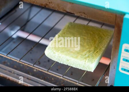 Toasten Sie Brot und Butter im elektrischen Mikroofen. Stockfoto