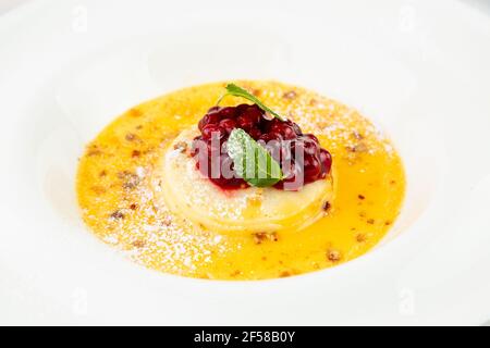 Ingwer-Kürbissuppe mit Knödeln und Beeren. Weißer Hintergrund Stockfoto