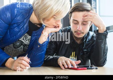 Der junge Ingenieur in Kiew denkt als Chefin über eine Lösung nach Versucht zu sehen, wie er die Arbeitsaufgabe löst Zur Modernisierung des Unternehmens Stockfoto