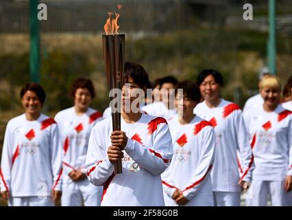 FUKUSHIMA, 25. März 2021 Iwashimizu Azusa (C), ein ehemaliges Mitglied der japanischen Fußballnationalmannschaft der Frauen, kommt am 25. März 2021 an einem Fackellauf an, um die Flamme während des Fackellaufs für die Olympischen Spiele in Tokio im J-Village National Training Center in Futaba, Fukushima, Japan, weiterzugeben. (Philip Fong/Pool via Xinhua) Stockfoto