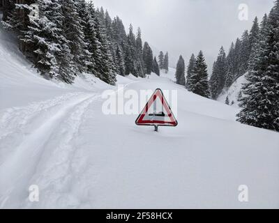 Starker Schneefall verursacht Warnschilder, die in die Passstraße sinken. Skitour auf dem Silberberg. Winterlandschaft. Stockfoto