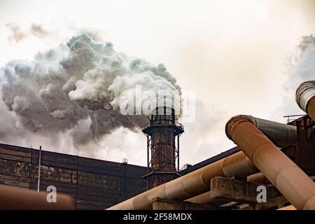 luftverschmutzung durch Bergbau und metallurgische Unternehmen. Dichter Rauch aus den Fabrikschornsteinen. Stockfoto