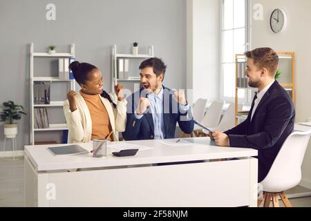 Junge Familie, die in der Bank sitzt, freut sich aufrichtig nach der Unterzeichnung Ein Kaufvertrag oder eine Kreditgenehmigung Stockfoto