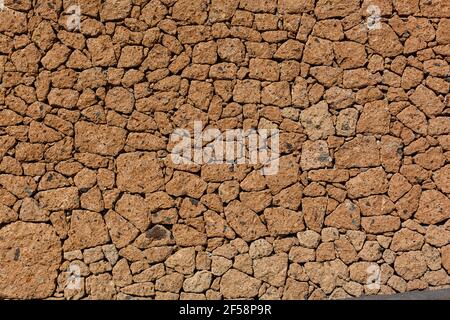 Stein Zaun Textur - Gebäude Funktion. Struktur von Betonzaun mit Relief und Textur wie eine orange Steinwand Stockfoto