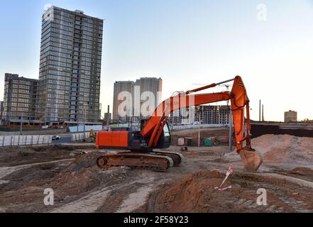 Bagger während der Aushubarbeiten auf der Baustelle. Bagger auf der Straße arbeiten. Maschinen für schwere Baumaschinen für Erdarbeiten. Bagger an der Brückenkonstruktion Stockfoto