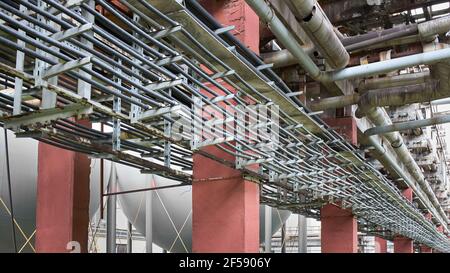 Kabelführung auf Stahlstützen. Reihen paralleler Stromkabel, die für die Stromversorgung von petrochemischen Produktionsanlagen verlegt sind. Industrie Stockfoto