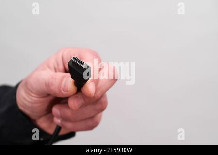 HDMI-Stecker in der Hand auf weißem Hintergrund. Stockfoto