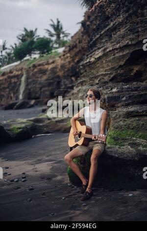 Romantischer junger Mann mit Gitarre am Strand Stockfoto
