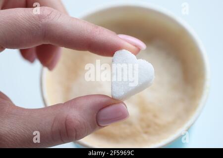 Frau setzen Kaffee Zucker Würfel in Form von Herz Nahaufnahme Stockfoto