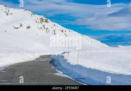 Schmale Straße durch einen schneebedeckten Bergpass mitten im Winter. Stockfoto