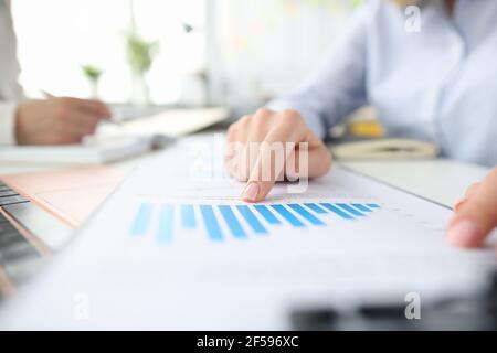 Frau zeigt mit Zeigefinger Wachstum des Gewinns in der Grafik Nahaufnahme Stockfoto