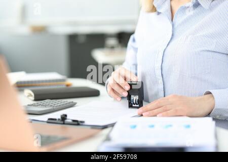 Geschäftsfrau, die in der Nahaufnahme des Büros einen Stempel auf das Dokument legt Stockfoto