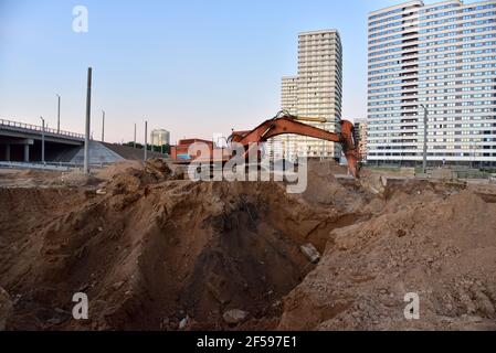 Bagger während der Aushubarbeiten auf der Baustelle. Bagger auf der Straße arbeiten. Maschinen für schwere Baumaschinen für Erdarbeiten. Bagger an der Brückenkonstruktion Stockfoto