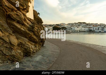 Herrlicher Sonnenaufgang in der wunderschönen Küstenstadt Cadaques in Katalonien, Spanien. Gemütliche Häuser am Mittelmeer leuchten durch die warme aufgehende Sonne mit Klippe. Stockfoto