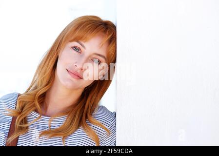 Nahaufnahme Porträt einer jungen Frau stehend und lehnenden Kopf An der Wand Stockfoto