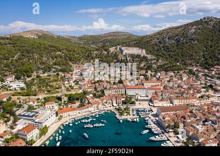 Atemberaubende Luftaufnahme der berühmten Insel Hvar und alt Stadt mit seinem Jachthafen und der Spannischen Festung in Kroatien an einem sonnigen Sommertag Stockfoto