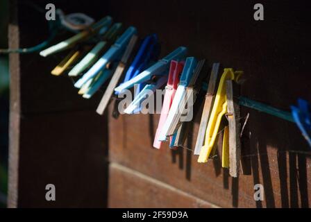 Bunte, alte Wäscheklammern an der Holzwand Stockfoto