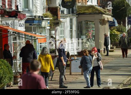 Tenterden, Großbritannien. 25th. März 2021. Zwei Leute sammeln einen Kaffee zum Mitnehmen, um in der Frühlingssonne in Tenterden im Weald of Kent, Großbritannien, zu genießen. Kredit: Richard Crease/Alamy Live Nachrichten Stockfoto