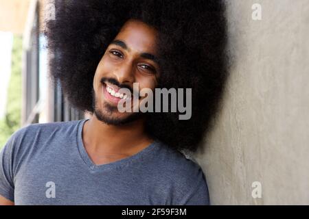 Nahaufnahme Porträt von glücklichen Mann mit Bart und Afro An der Wand gelehnt Stockfoto