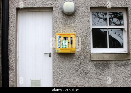 Sanquhar, Dumfries & Galloway, Schottland, Großbritannien. März 2021, 22. Lebensrettender Defibrillator für den öffentlichen Gebrauch an der Wand des Gebäudes Stockfoto