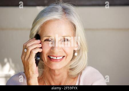 Nahaufnahme Porträt der schönen älteren Frau im Gespräch auf Zelle Telefon draußen Stockfoto