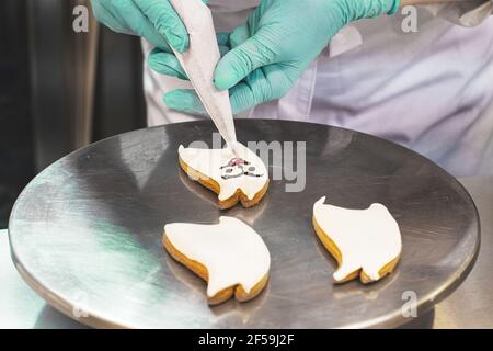 Der Konditor schmückt das Dessert mit einem Tütchen. Eine Meisterklasse. Nahaufnahme. Hochwertige Fotos Stockfoto