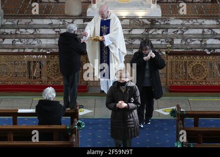 Canon Tom White hält einen Massendienst in St. Mary's Catholic Chuch in Calton, Glasgow, nachdem Coronavirus-Vorschriften, die die Schließung von Kirchen in Schottland und kriminalisierte öffentlichen Gottesdienst wurden als rechtswidrig vom Gerichtshof der Sitzung. Kirchen sollen am Freitag unter Anleitung der schottischen Regierung geöffnet werden. Bilddatum: Donnerstag, 25. März 2021. Stockfoto