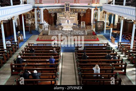 Canon Tom White hält einen Massendienst in St. Mary's Catholic Chuch in Calton, Glasgow, nachdem Coronavirus-Vorschriften, die die Schließung von Kirchen in Schottland und kriminalisierte öffentlichen Gottesdienst wurden als rechtswidrig vom Gerichtshof der Sitzung. Kirchen sollen am Freitag unter Anleitung der schottischen Regierung geöffnet werden. Bilddatum: Donnerstag, 25. März 2021. Stockfoto