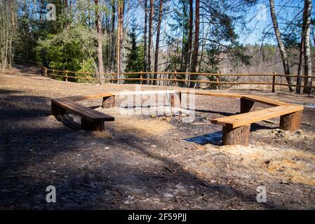 Kamin auf dem Campingplatz mit hölzernen Tälern zur Ruhe. Umgeben von einem schönen Wald mit Blick auf den Fluss. Frühlingslandschaft Stockfoto