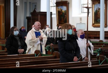 Canon Tom White hält einen Massendienst in St. Mary's Catholic Chuch in Calton, Glasgow, nachdem Coronavirus-Vorschriften, die die Schließung von Kirchen in Schottland und kriminalisierte öffentlichen Gottesdienst wurden als rechtswidrig vom Gerichtshof der Sitzung. Kirchen sollen am Freitag unter Anleitung der schottischen Regierung geöffnet werden. Bilddatum: Donnerstag, 25. März 2021. Stockfoto