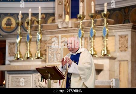 Canon Tom White hält einen Massendienst in St. Mary's Catholic Chuch in Calton, Glasgow, nachdem Coronavirus-Vorschriften, die die Schließung von Kirchen in Schottland und kriminalisierte öffentlichen Gottesdienst wurden als rechtswidrig vom Gerichtshof der Sitzung. Kirchen sollen am Freitag unter Anleitung der schottischen Regierung geöffnet werden. Bilddatum: Donnerstag, 25. März 2021. Stockfoto