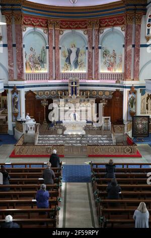 Canon Tom White hält einen Massendienst in St. Mary's Catholic Chuch in Calton, Glasgow, nachdem Coronavirus-Vorschriften, die die Schließung von Kirchen in Schottland und kriminalisierte öffentlichen Gottesdienst wurden als rechtswidrig vom Gerichtshof der Sitzung. Kirchen sollen am Freitag unter Anleitung der schottischen Regierung geöffnet werden. Bilddatum: Donnerstag, 25. März 2021. Stockfoto