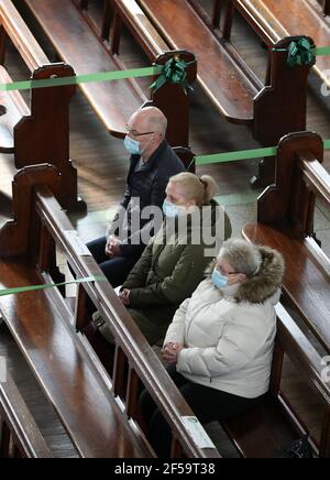 Gemeindemitglieder sitzen als Canon Tom White hält einen Massendienst in St. Mary's Catholic Chuch in Calton, Glasgow, nachdem Coronavirus-Vorschriften, die die Schließung von Kirchen in Schottland und kriminalisierte öffentlichen Gottesdienst wurden als rechtswidrig vom Gericht der Sitzung. Kirchen sollen am Freitag unter Anleitung der schottischen Regierung geöffnet werden. Bilddatum: Donnerstag, 25. März 2021. Stockfoto