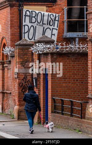 London, Großbritannien. März 2021, 25. Abschaffung der Polizei - Hausbesetzer und Aktivisten haben die ehemalige Clapham Common Police Station besetzt, um "den Abzug des Gesetzes über Polizei, Verbrechen, Verurteilung und Gerichte und das Ende des Frauenmordes zu fordern, das kürzlich durch den Mord an Sarah Everard durch einen dienstbedienten Met-Polizisten hervorgehoben wurde". Es wäre die nächste Station gewesen, wo Sarah zuletzt gesehen wurde. Obwohl der Gesetzentwurf derzeit verschoben wurde, wollen sie sicherstellen, dass er nicht verabschiedet wird, und versuchen auch, Abschnitt 4 des Gesetzentwurfs hervorzuheben, der die Übertretung kriminalisiert. Das Gebäude ist mit anarchistischen Symb übertüncht Stockfoto