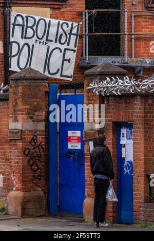 London, Großbritannien. März 2021, 25. Einige Leute kommen auf und versuchen einzusteigen, aber die meisten gehen unbeantwortet weg - unter einer Abschaffung der Polizei Banner - Besetzer und Aktivisten haben die ehemalige Clapham Common Police Station besetzt, um zu fordern "den Abzug der Polizei, Verbrechen, Verurteilung und Gerichte Bill und das Ende des Frauenmordes vor kurzem durch den Mord an Sarah Everard durch einen Dienst Met Polizeioffizier hervorgehoben." Es wäre die nächste Station gewesen, wo Sarah zuletzt gesehen wurde. Obwohl der Gesetzesentwurf derzeit verschoben wurde, wollen sie sicherstellen, dass er nicht verabschiedet wird, und versuchen auch, Sectio hervorzuheben Stockfoto