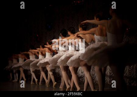 Ballerinas sind in einer Reihe. Die Mädels sind nacheinander auf der Bühne aufgereiht. Ballerinas in weißem Tutus haben den Rücken zur Kamera. Mädchen Perf Stockfoto