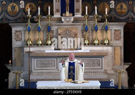 Canon Tom White hält einen Massendienst in St. Mary's Catholic Chuch in Calton, Glasgow, nachdem Coronavirus-Vorschriften, die die Schließung von Kirchen in Schottland und kriminalisierte öffentlichen Gottesdienst wurden als rechtswidrig vom Gerichtshof der Sitzung. Kirchen sollen am Freitag unter Anleitung der schottischen Regierung geöffnet werden. Bilddatum: Donnerstag, 25. März 2021. Stockfoto